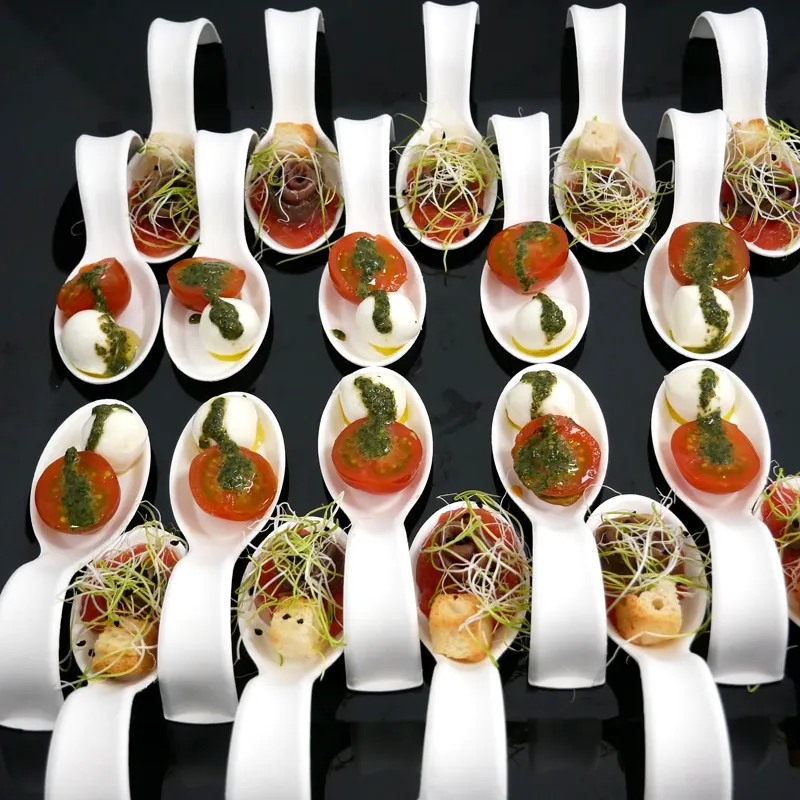 Cucharitas de aperitivo del catering servidas en fila