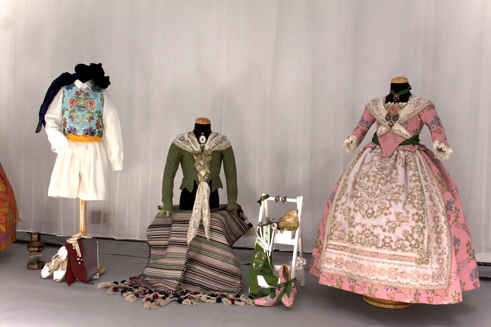 Trajes de valenciana de colores expuestos en maniquíes con complementos
