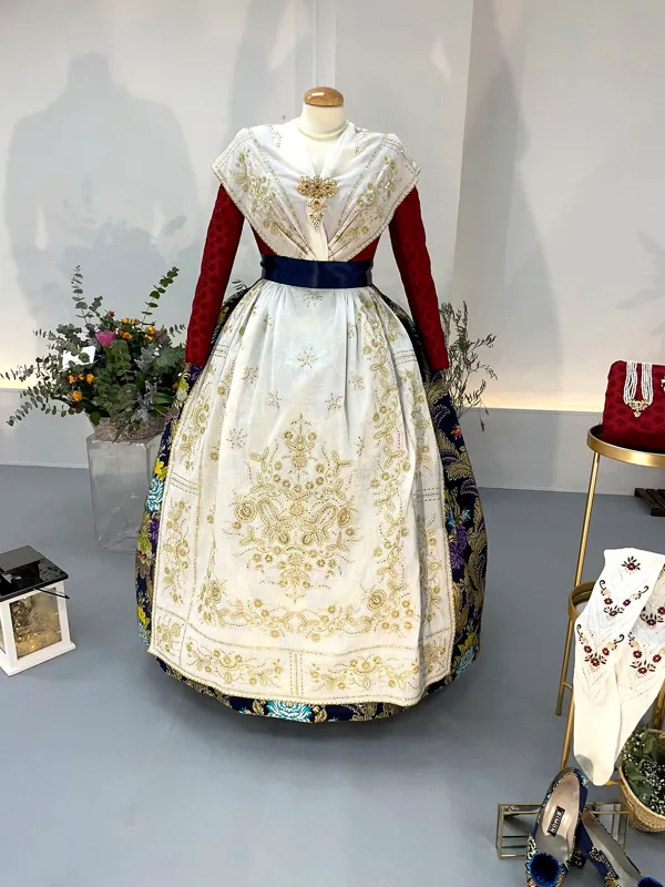 Trajes de fallera expuestos con un aro decorado con flores