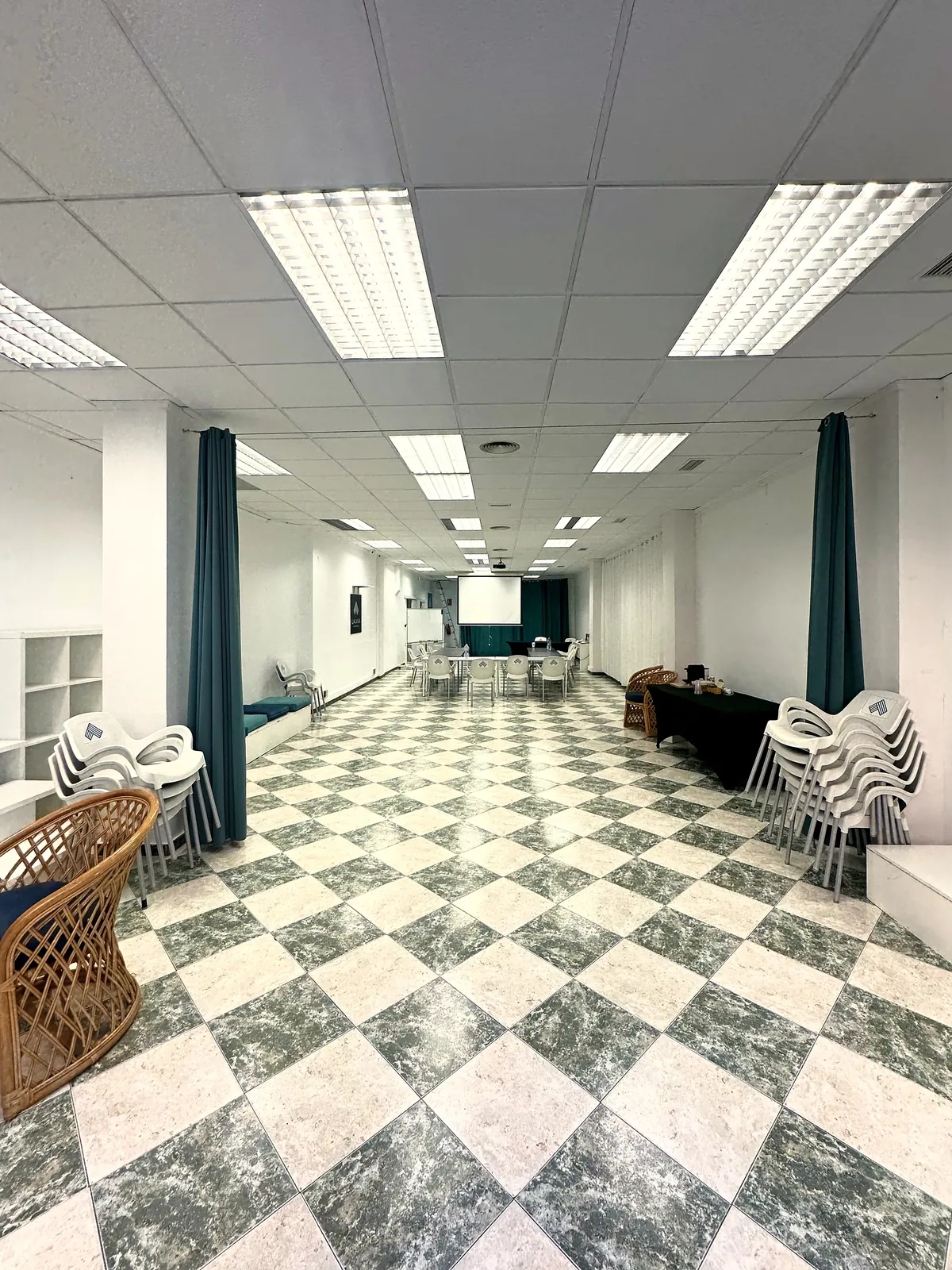 La sala de Lacasa a lo largo, con suelo a cuadros verde y crema y cortinas verdes